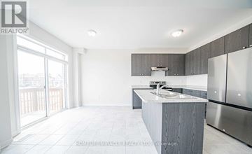 Oshawa (Taunton) apartment for rent - A modern kitchen with a large island and stainless steel appliances.