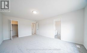 Oshawa (Taunton) apartment for rent - A spacious, empty room with white walls and carpeted floor.