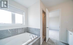 Oshawa (Taunton) apartment for rent - A bathroom with a tub and a doorway leading to another room.