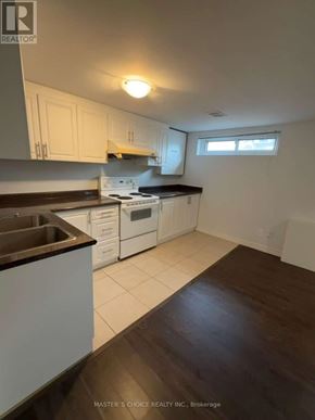 Richmond Hill (Crosby) apartment for rent - A kitchen with white cabinets and a black countertop.