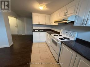 Richmond Hill (Crosby) apartment for rent - A kitchen with white cabinets and a black countertop.