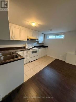Richmond Hill (Crosby) apartment for rent - A kitchen with white cabinets and a black countertop.