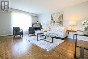 Hamilton (Berrisfield) multi-family for rent - A living room with a white couch, a coffee table, and a painting on the wall.