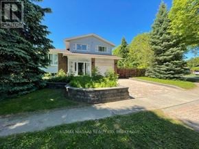 Niagara Falls (Morrison) apartment for rent - A house with a well-maintained lawn and a stone wall in front.