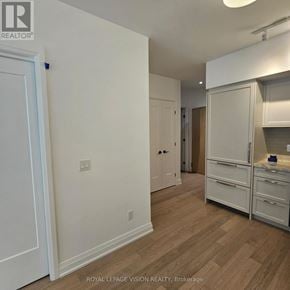 Toronto (Englemount-Lawrence) condo for rent - A white kitchen with a white door and white cabinets.
