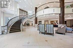 Toronto (Don Valley Village) condo for rent - A spacious lobby with a curved staircase and a variety of seating options.