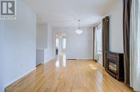 Toronto (Cliffcrest) apartment for rent - A spacious room with wooden floors and white walls.