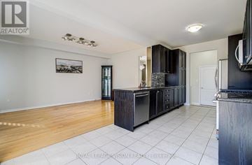 Toronto (Cliffcrest) apartment for rent - A kitchen with black cabinets and a white tile floor.