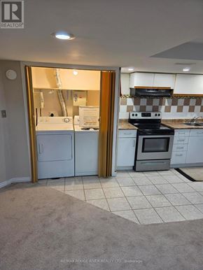 Toronto (Rouge) apartment for rent - A kitchen with a white fridge and black stove.