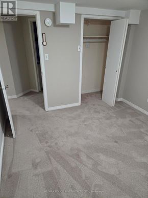 Toronto (Rouge) apartment for rent - A carpeted room with a white door and a white wall.