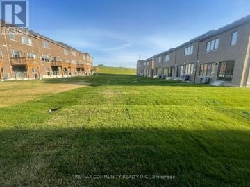 Pickering townhouse for rent - A grassy field in front of apartment buildings.