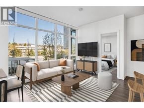 Burnaby apartment for rent - A living room with a large window overlooking a cityscape.