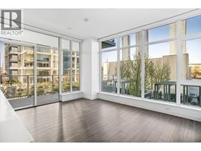 Burnaby apartment for rent - A spacious room with a view of a cityscape through large windows.