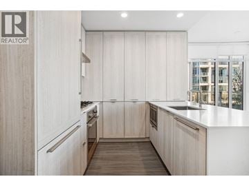 Burnaby apartment for rent - A modern kitchen with wooden cabinets and a white countertop.