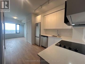 Vaughan (Concord) condo for rent - A kitchen with white cabinets and a black stove top.