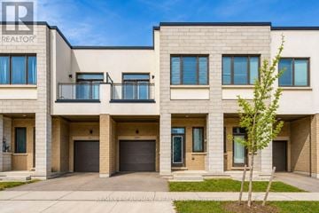 Oakville (Go Glenorchy) townhouse for rent - A building with a tree in front of it.