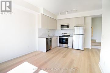St. Catharines (E. Chester) townhouse for rent - A kitchen with white cabinets and a wooden floor.