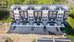 St. Catharines (E. Chester) townhouse for rent - A large apartment building with a parking lot in front.