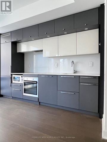 Toronto (Bay Street Corridor) condo for rent - A modern kitchen with a stainless steel refrigerator and a double oven.