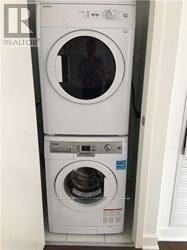Toronto (Bay Street Corridor) condo for rent - A white front loading washing machine with a black door.