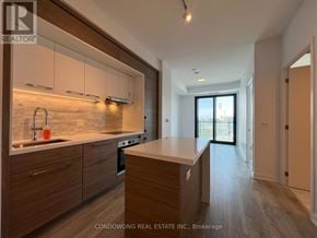 Toronto (Bayview Village) condo for rent - A modern kitchen with wooden cabinets and a countertop.