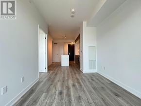 Toronto (Bayview Village) condo for rent - A spacious room with wood flooring and white walls.