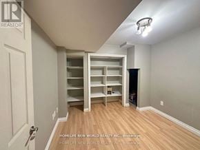 Richmond Hill (Rouge Woods) apartment for rent - A room with a built-in shelving unit and a door on the left.