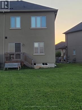 Brant (Paris) townhouse for rent - A house with a deck and a green lawn in front.