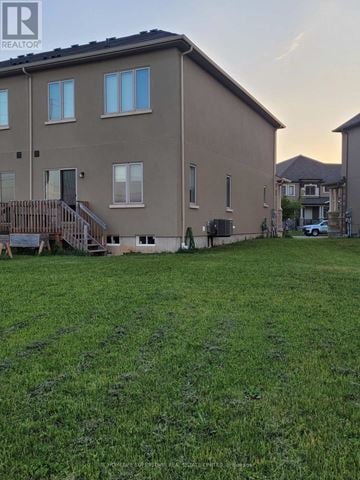 Brant (Paris) townhouse for rent - A large grassy yard in front of a two-story building.