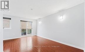Toronto (West Hill) townhouse for rent - A room with wooden flooring and white walls, with a window and a door leading to a balcony.