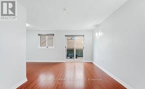 Toronto (West Hill) townhouse for rent - A spacious room with wooden flooring and white walls.