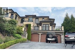 West Vancouver apartment for rent - A large house with a garage and two cars parked in front.
