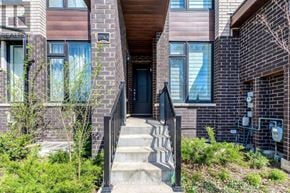 Toronto (Rustic) townhouse for rent - A modern house with a black front door and a wooden balcony.