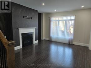 Innisfil (Alcona) apartment for rent - A large, empty room with a fireplace and wooden floors.