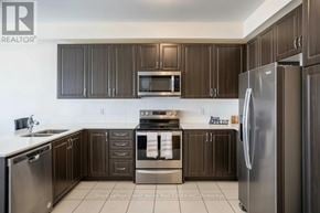 Innisfil (Alcona) apartment for rent - A kitchen with dark brown cabinets and stainless steel appliances.