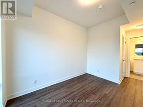 Clarington (Bowmanville) condo for rent - A room with white walls and wooden flooring, with a doorway leading to another room.
