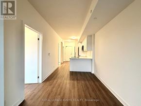Clarington (Bowmanville) condo for rent - A long hallway with white walls and wood floors.