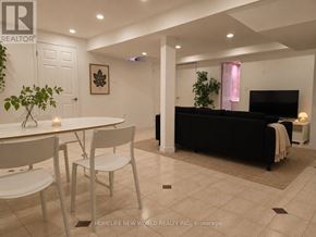 Markham (Middlefield) apartment for rent - A living room with a black couch and a dining table with chairs.