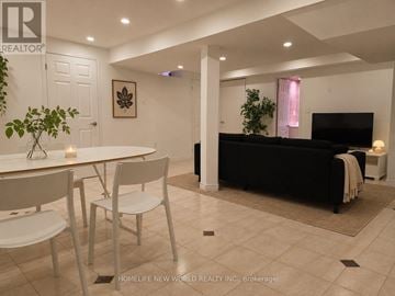 Markham (Middlefield) apartment for rent - A living room with a black couch and a dining table with chairs.