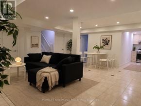Markham (Middlefield) apartment for rent - A living room with a black couch and a white coffee table.