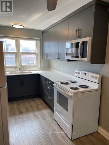 Halton Hills (Georgetown) multi-family for rent - A kitchen with a white stove top oven and a window.