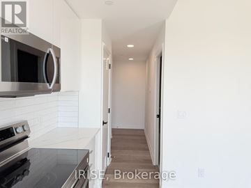 Brantford condo for rent - A modern kitchen with a stove top oven and microwave above it.