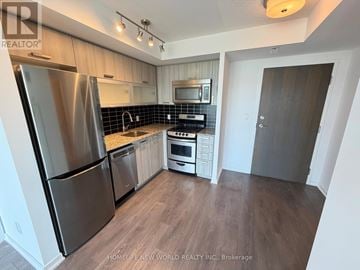 Toronto (Little Portugal) condo for rent - A kitchen with a refrigerator, oven, and microwave.