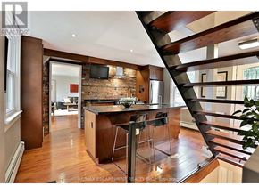 Burlington (Bayview) apartment for rent - A modern kitchen with a bar stool and a staircase.