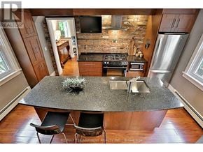 Burlington (Bayview) apartment for rent - A kitchen with a granite countertop and a brick wall.