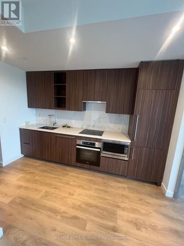 Toronto (Bayview Village) condo for rent - A modern kitchen with wooden cabinets and stainless steel appliances.