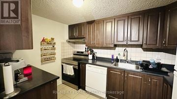 Ottawa condo for rent - A kitchen with brown cabinets and a black countertop.