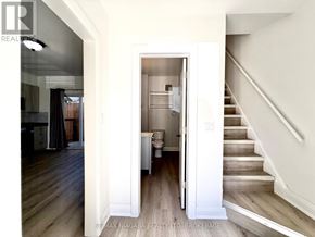 Niagara Falls (Downtown) multi-family for rent - A hallway with a staircase and a doorway leading to a kitchen.