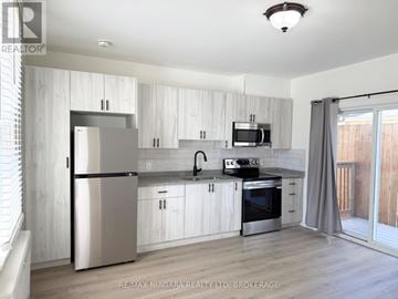 Niagara Falls (Downtown) multi-family for rent - A modern kitchen with white cabinets and stainless steel appliances.
