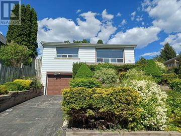 Toronto (Clairlea-Birchmount) apartment for rent - A white house with a brown garage door surrounded by greenery.
